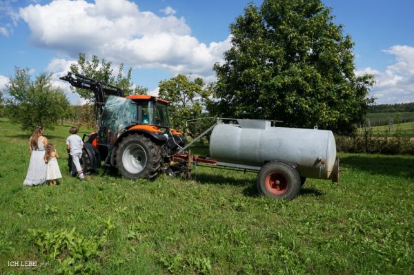 Die Kinder besteigen neugierig den Traktor.